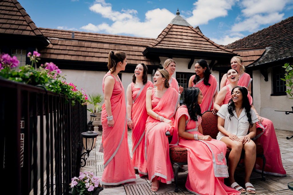 Bridal party poses for a fun and vibrant photo on the Pleasantdale Chateau bridal suite balcony.